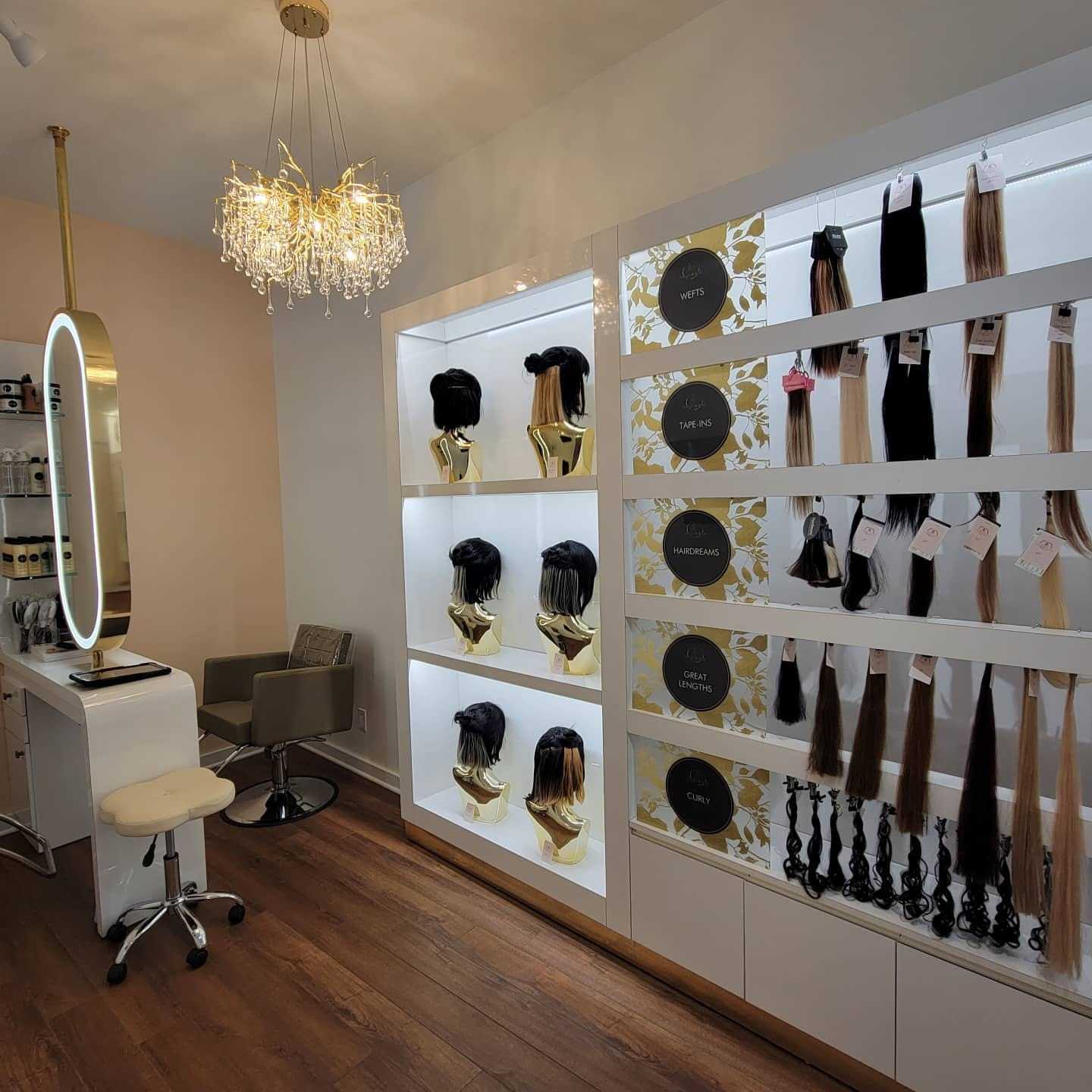 Hair salon interior with wigs and extensions on display under elegant lighting.